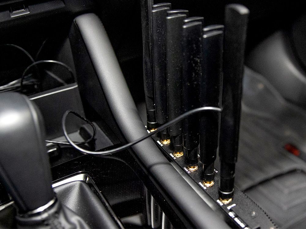 De Peplink MAX BR2 Pro 5G router geplaatst in een auto aan de bijrijderskant naast de versnellingspook