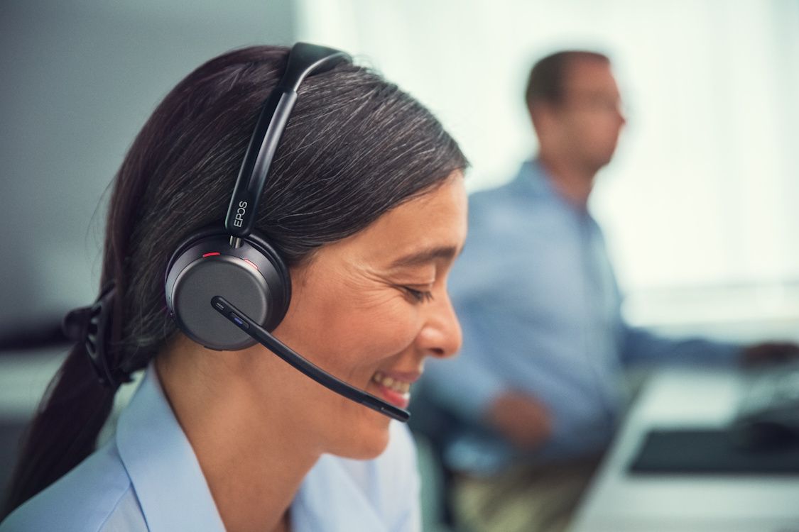 Een vrouw draagt de EPOS IMPACT 1000 MS UC Mono WL Bluetooth Headset op kantoor
