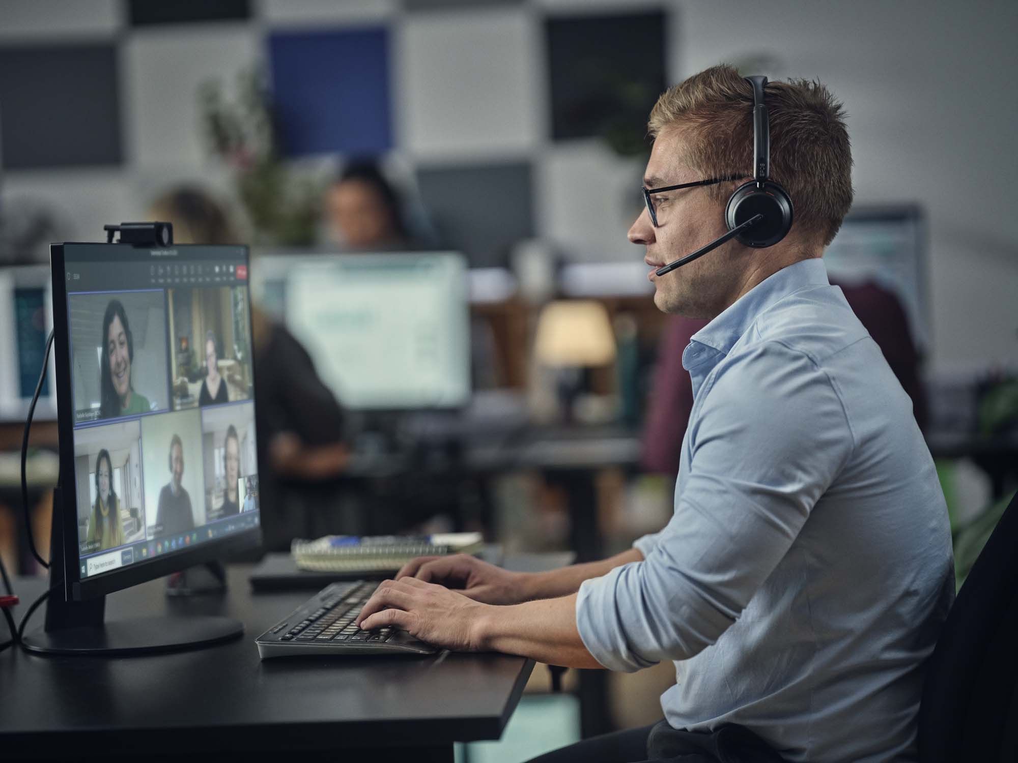 Een man draagt de EPOS IMPACT 1000 MS UC Mono WL Bluetooth Headset op kantoor