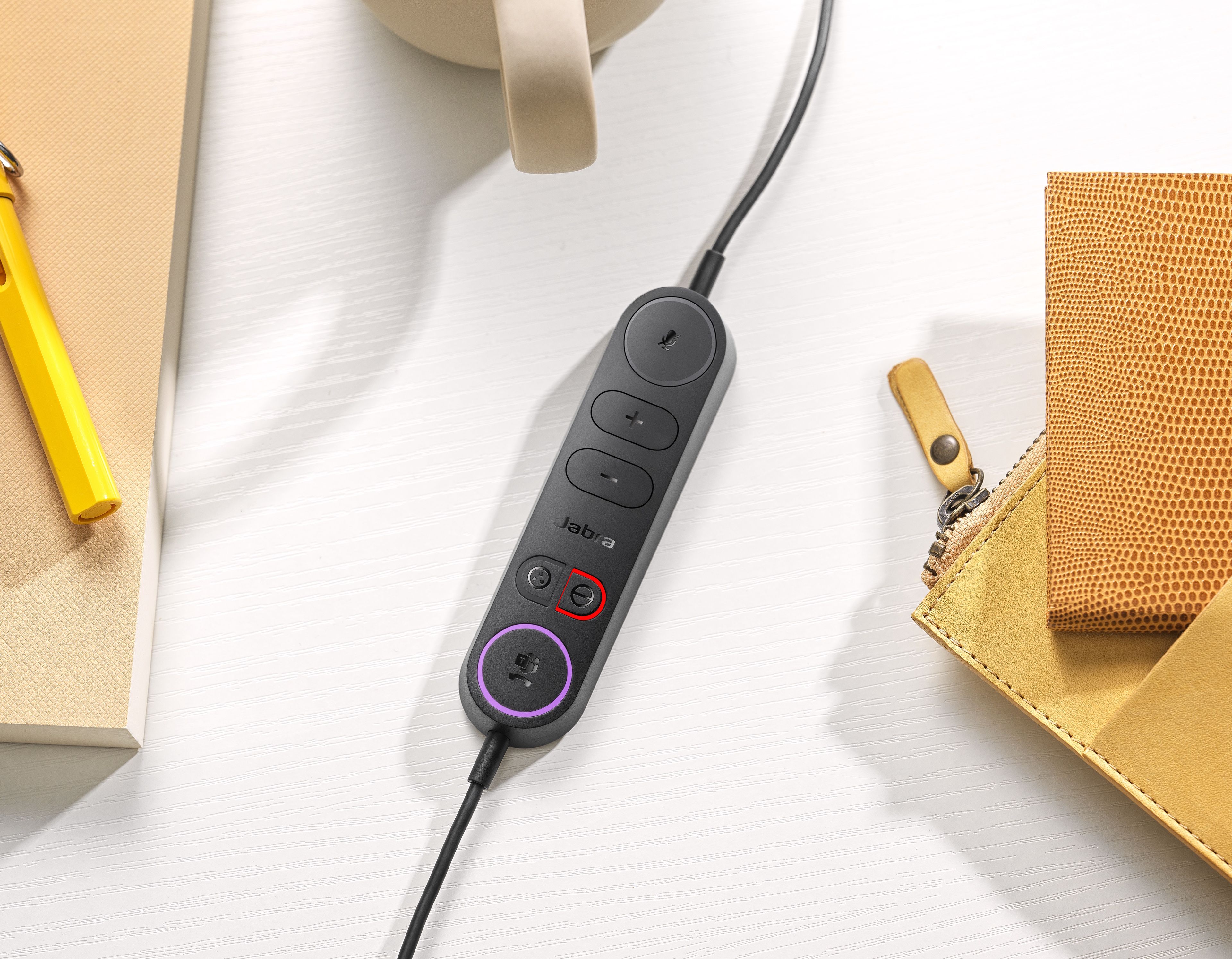 De inline call control unit van de Jabra Engage 40 MS Teams stereo USB-C/A headset tussen spullen op een bureau