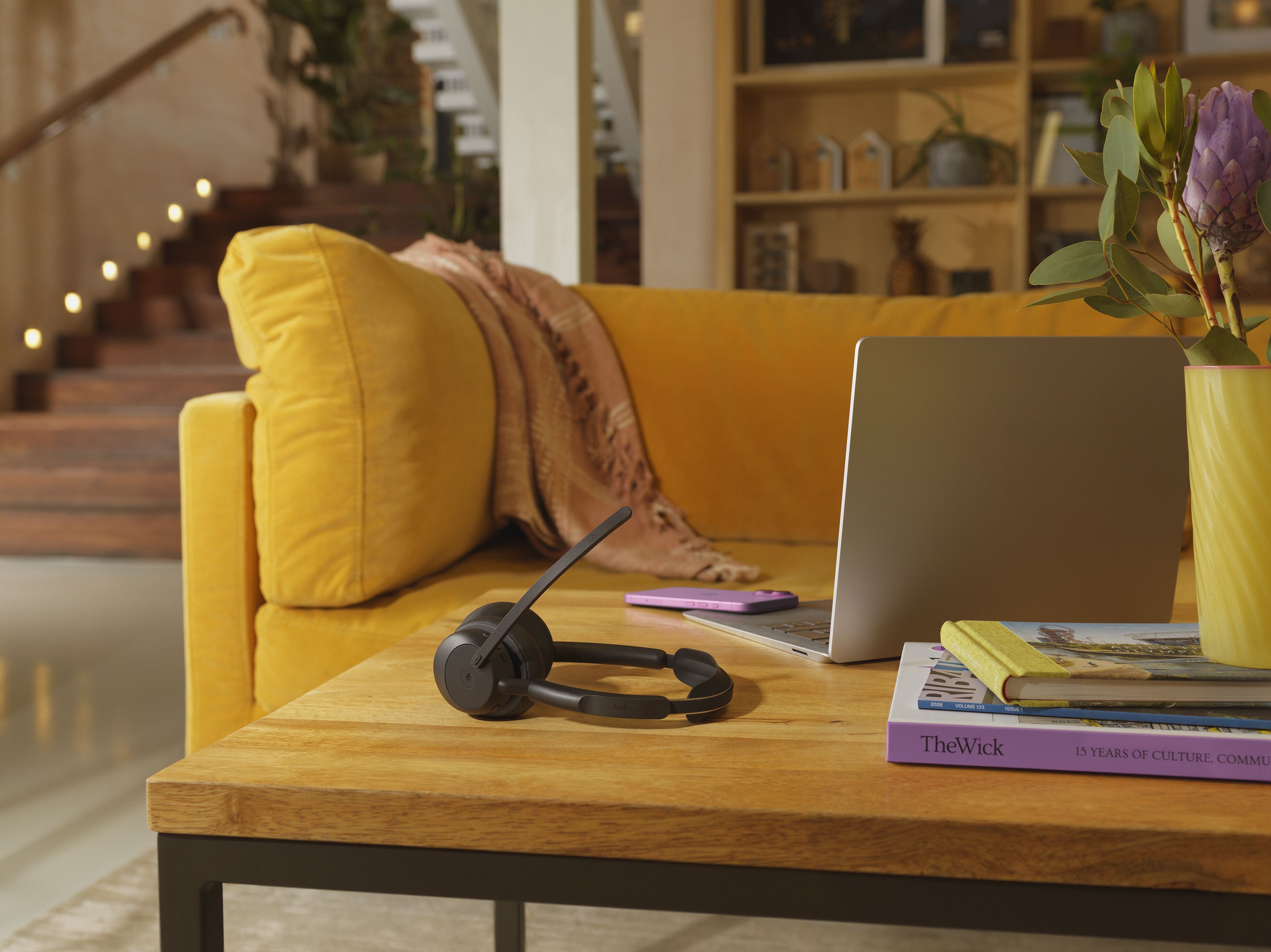 Jabra Evolve3 45 MS Teams stereo Bluetooth headset op een tafel met een laptop in een (thuis)kantoor met gele bank