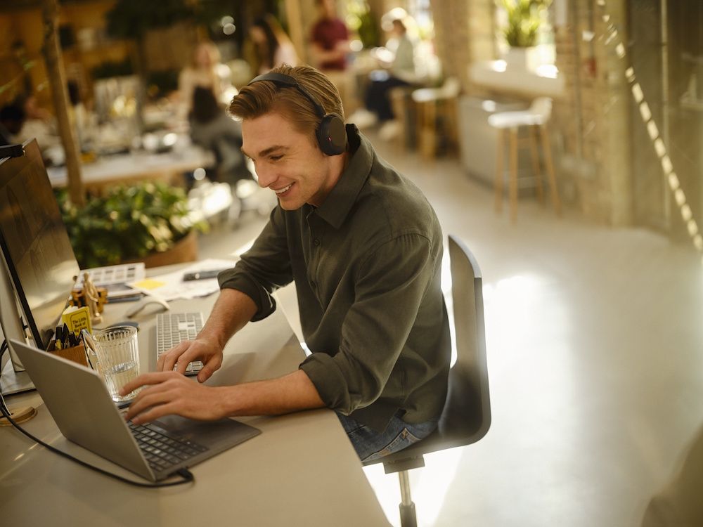 De Jabra Evolve3 65 Flex UC Bluetooth headset wordt gebruikt op een flexibele werkplek tijdens hybride werken
