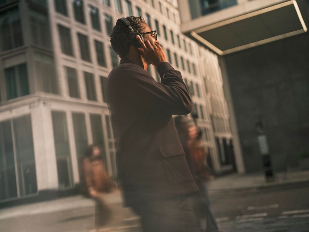 Een zakelijke professional draagt de draadloze Jabra Evolve3 75 MS Bluetooth headset onderweg op straat