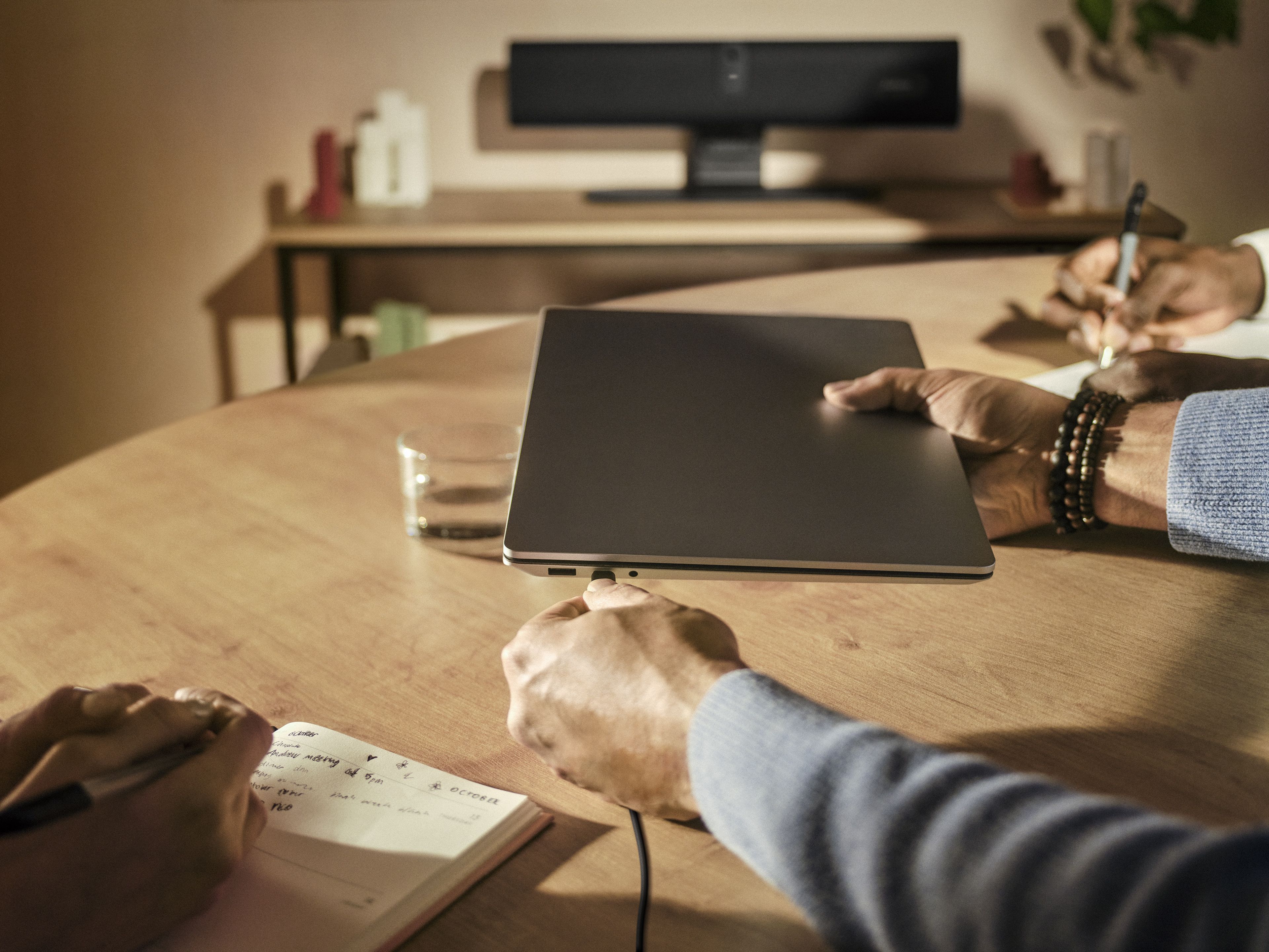 De compacte Jabra PanaCast U30 USB videobar voor kleine vergaderruimtes staat op een tafelstandaard en wordt aangesloten op een laptop