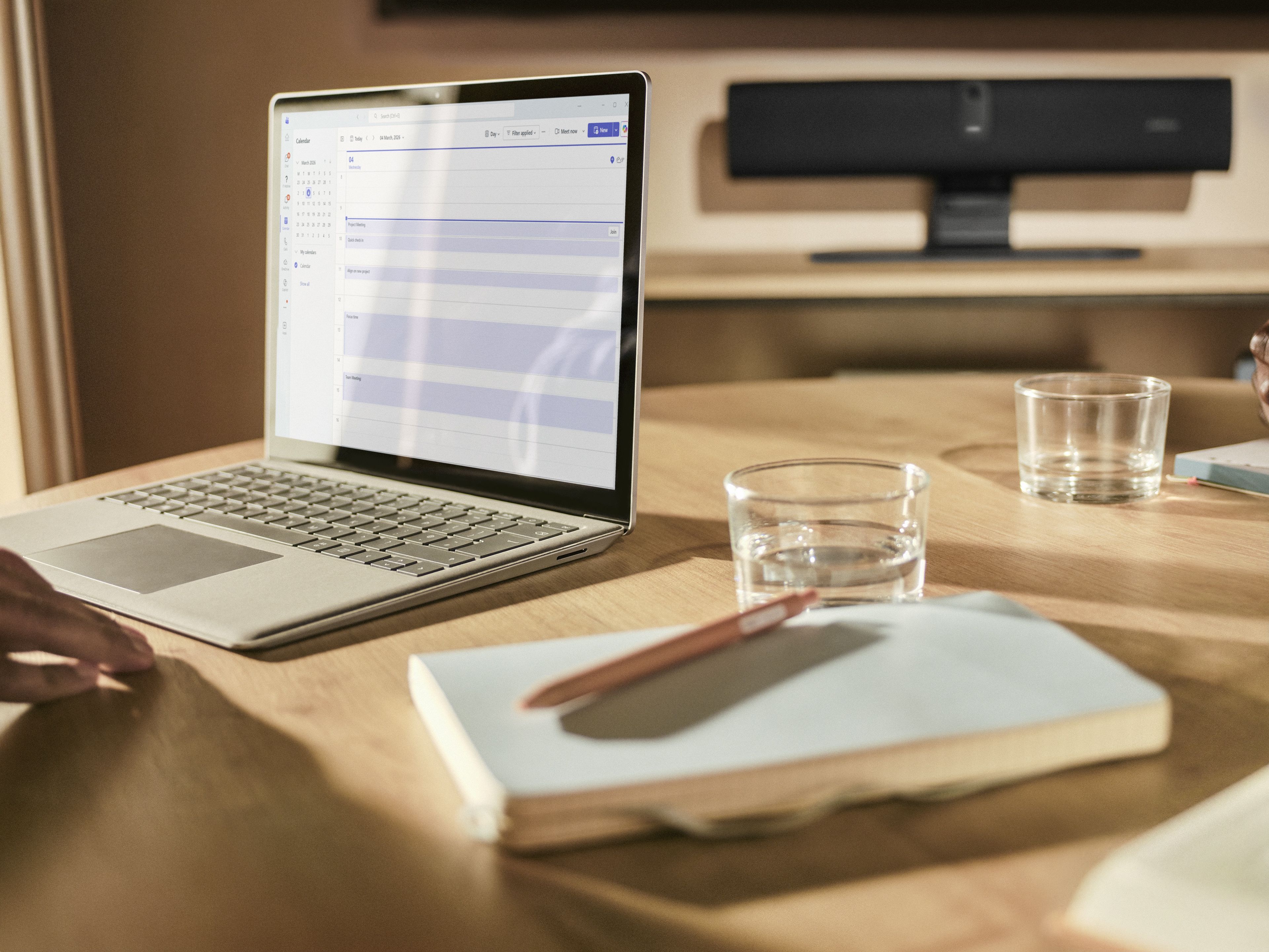 De compacte Jabra PanaCast U30 USB videobar voor kleine vergaderruimtes staat op een tafelstandaard in een Teams Rooms vergaderruimte