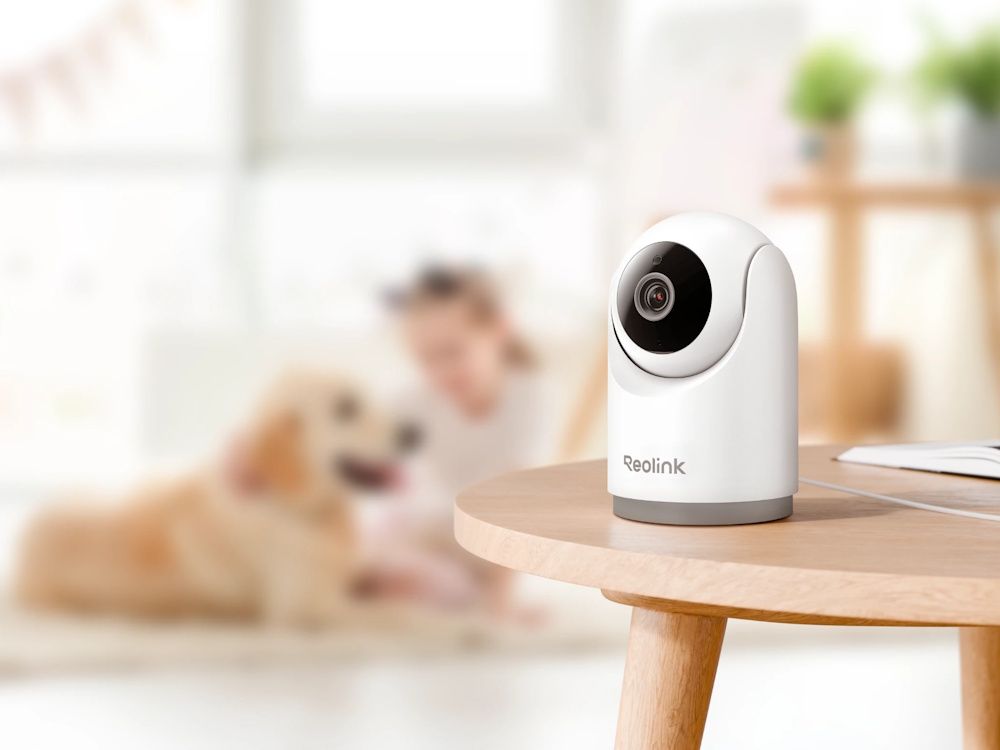 De Reolink E331 indoor 5MP PT WiFi 6 camera op een tafeltje in een woonkamer