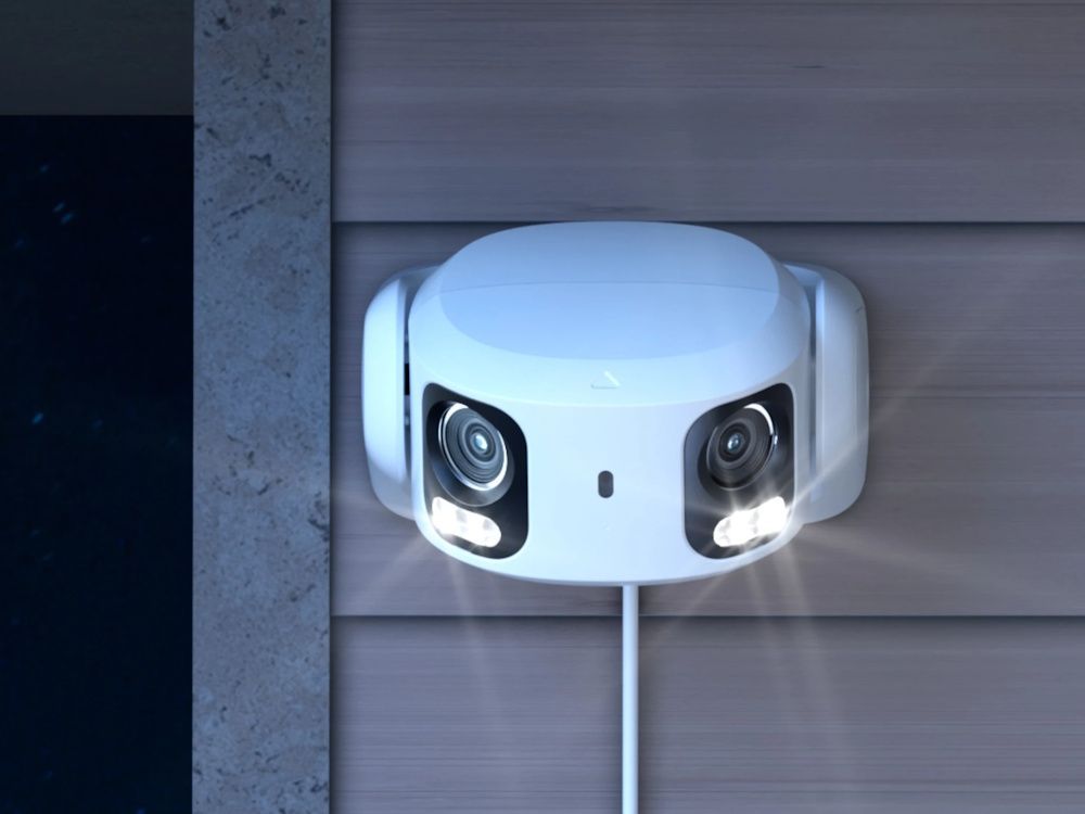 De Reolink RP-PCT16MD-W dual-lens 16MP PoE camera met 180° panoramisch zicht buiten aan een wand gemonteerd met spotlights aan