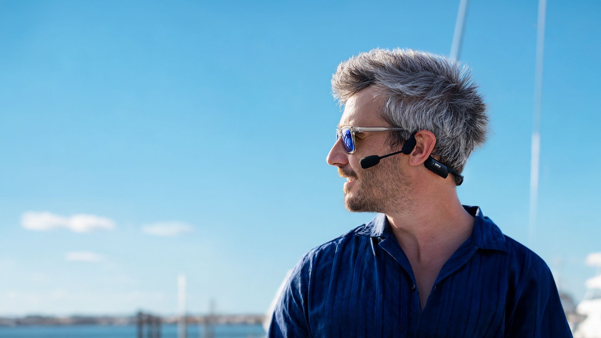 Een man op een boot draagt de Sena Nautitalk Open Bone Conduction Marine Headset