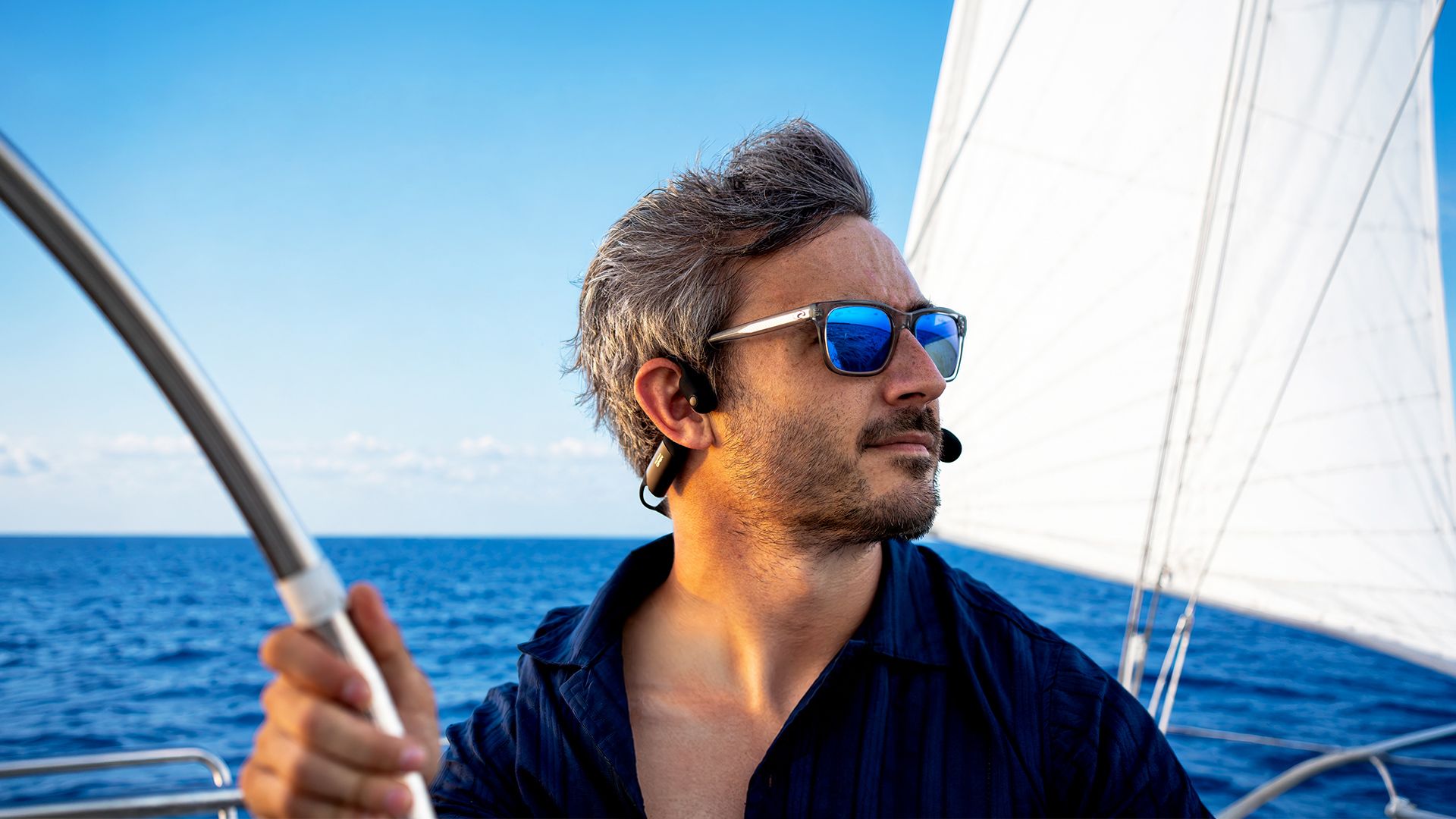 Een man draagt de Sena Nautitalk Open Bone Conduction Marine Headset op een boot