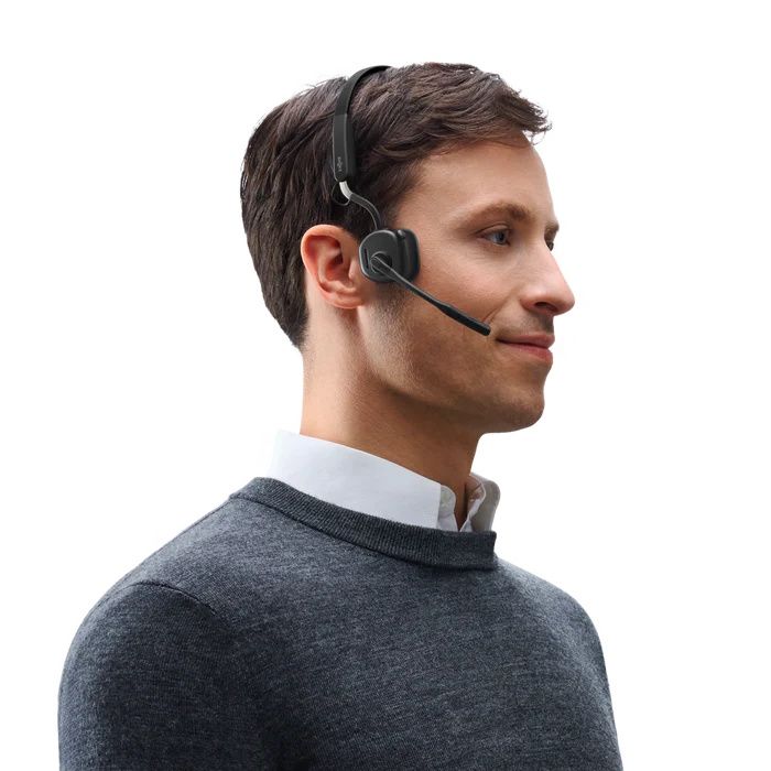 Een man draagt de Shokz OpenMeet UC bone conduction en air conduction open-ear headset