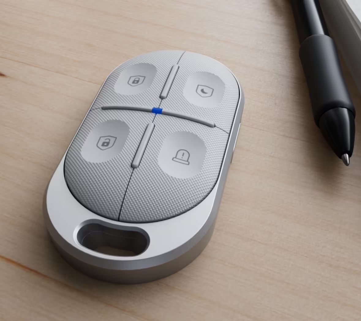 De Ubiquiti UniFi SuperLink Remote Control KeyFob (USL-FOB) naast een pen op een houten ondergrond