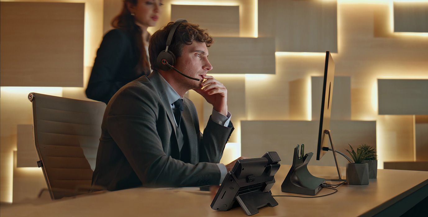 Een man draagt de Yealink WH68 Workstation UC headset met DECT en Bluetooth op kantoor