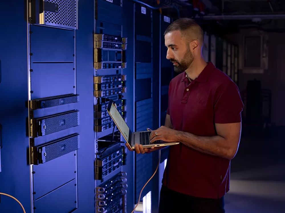 De Axis Camera Station S1216 Rack Recording Server geplaatst in een serverkast met een beheerder ernaast