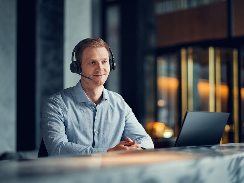 De EPOS IMPACT 500 draadloze Bluetooth headset in gebruik door een man met een laptop