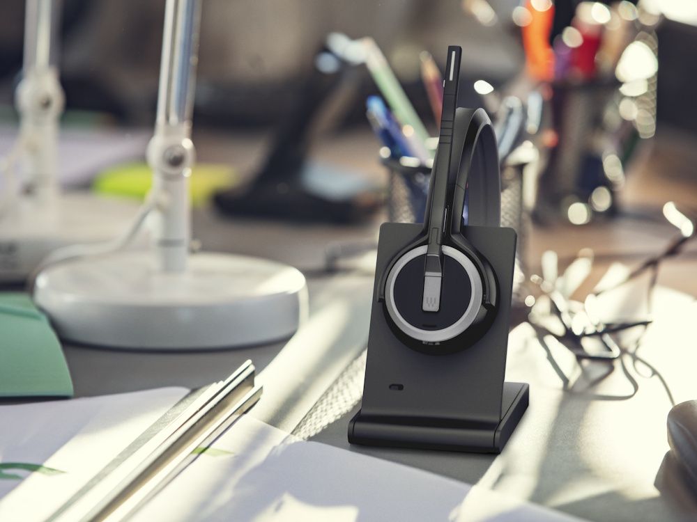 De EPOS IMPACT 5000 Go MS stereo DECT headset op de laadstandaard op een bureau