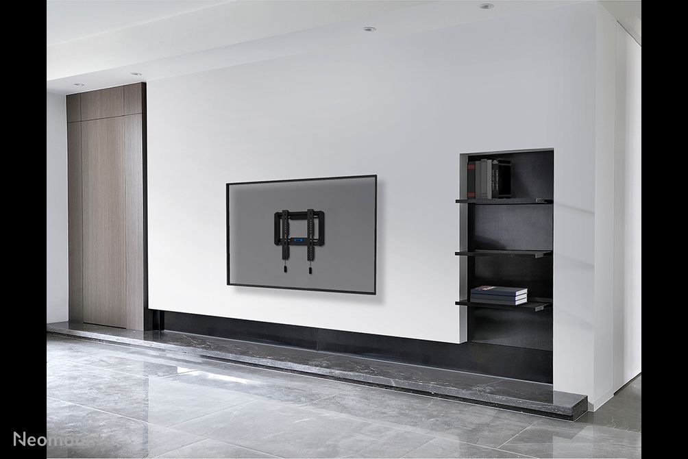 De Neomounts WL30-550BL12 muurbeugel voor displays van 24'' tot 65'' aan de muur in een zakelijke ruimte