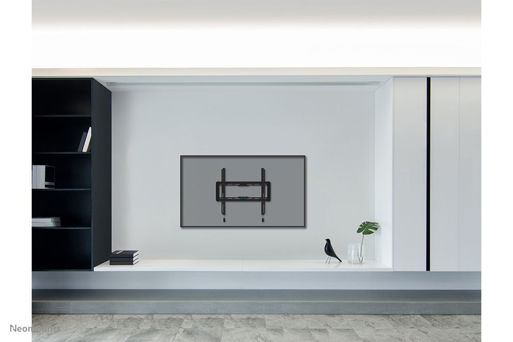 De Neomounts WL30-550BL14 muurbeugel voor displays van 32'' tot 75'' aan de muur gemonteerd in een strakke omgeving