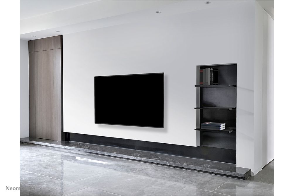 Een beeldscherm aan de muur gemonteerd in een zakelijke omgeving met de Neomounts WL30-550BL14 muurbeugel voor displays van 32'' tot 75''