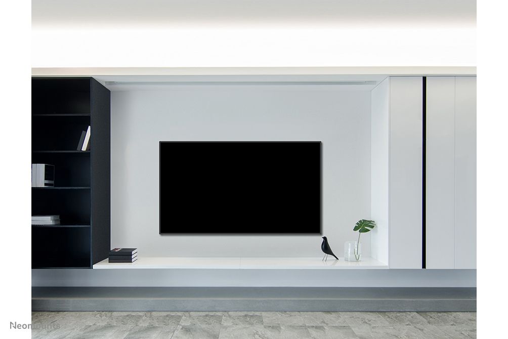 Een beeldscherm aan de muur opgehangen met een Neomounts WL30-550BL18 muurbeugel voor displays van 43'' tot 86'' in een strakke omgeving