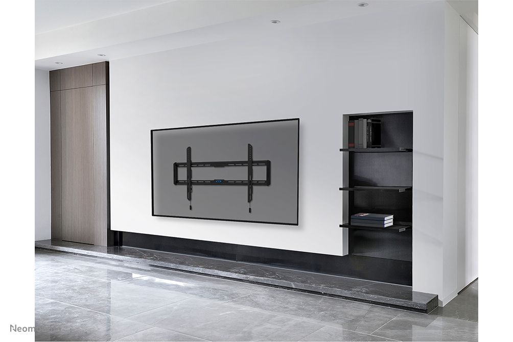 De Neomounts WL30-550BL18 muurbeugel voor displays van 43'' tot 86'' aan de wand gemonteerd in een zakelijke omgeving