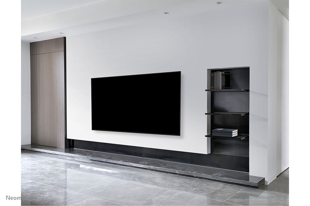 Een beeldscherm aan de wand opgehangen met de Neomounts WL30-550BL18 muurbeugel voor displays van 43'' tot 86'' in een zakelijke omgeving