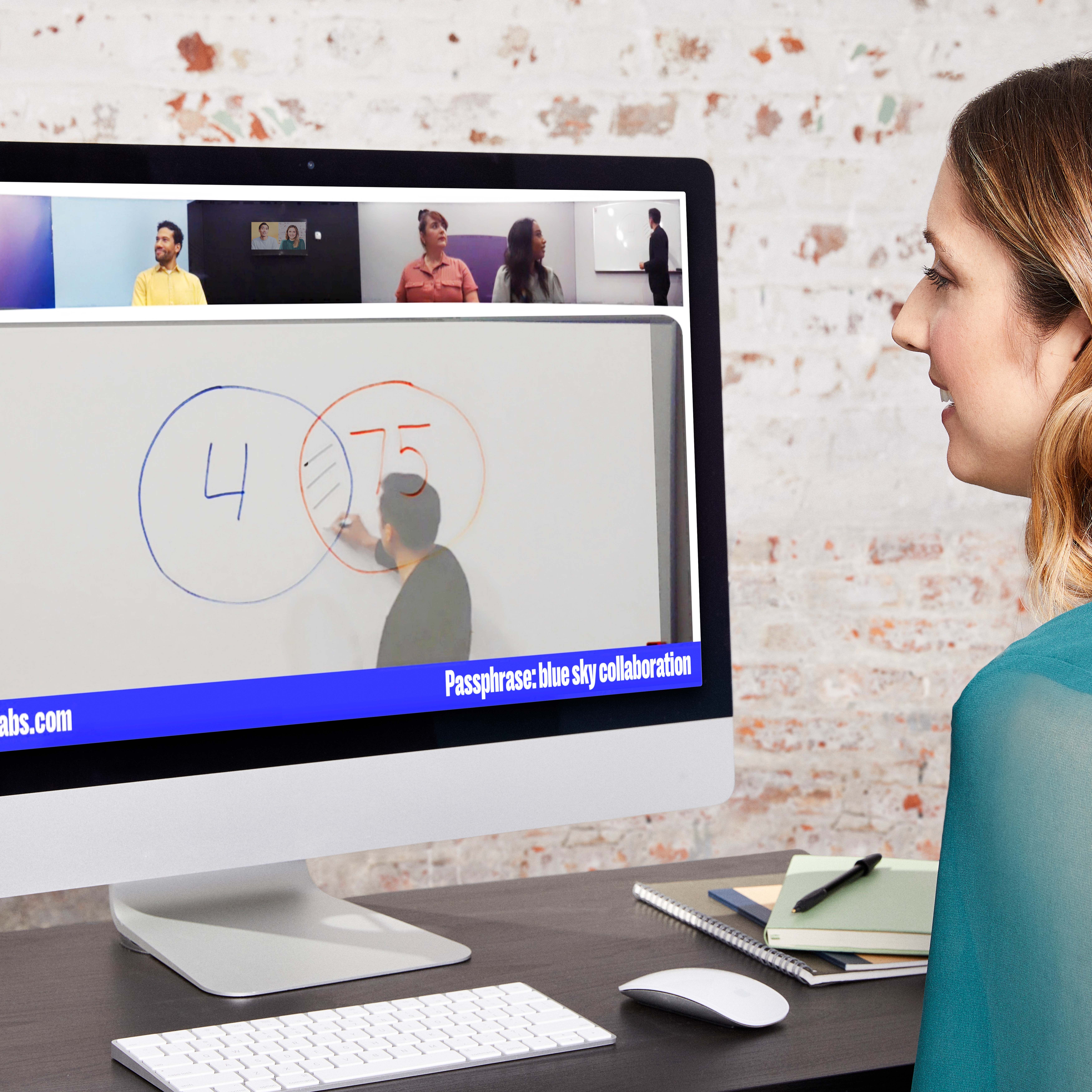 Een medewerker die remote of hybride werkt kijkt mee tijdens een hybride vergadering dankzij de Owl Labs Whiteboard Owl camera.