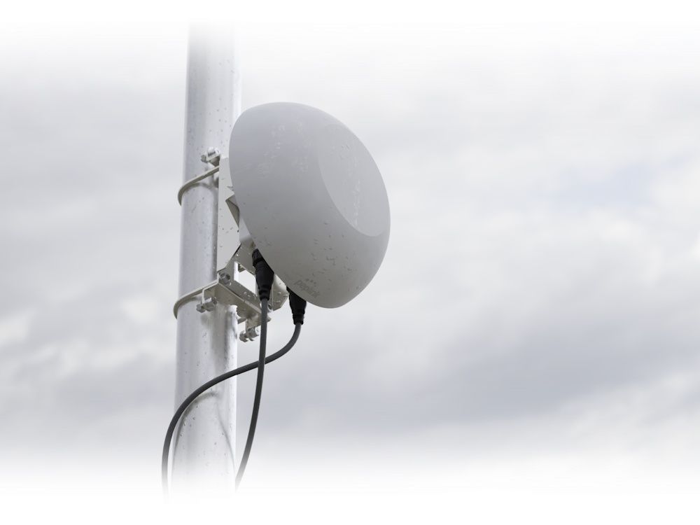 Sfeerafbeelding met de Peplink MAX HD1 Dome Pro 5G router buiten aan een paal of mast gemonteerd met de montagebeugel