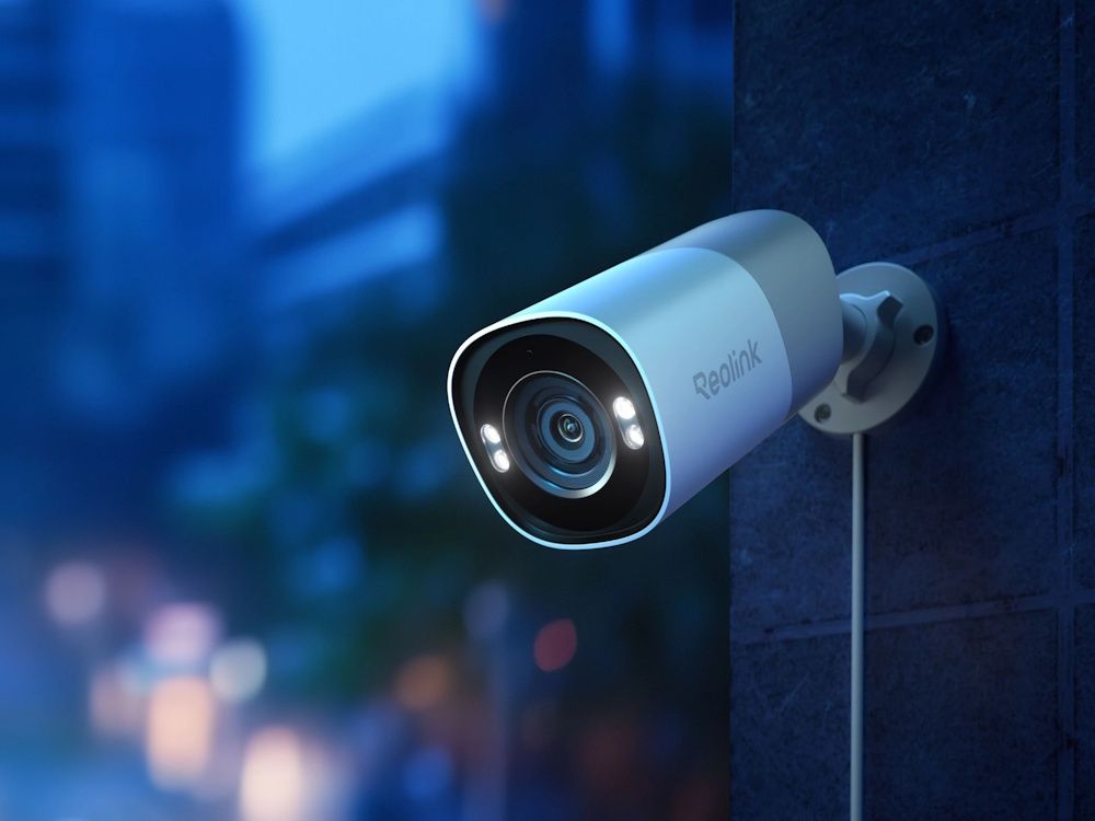 De Reolink Pro RP-PCB8MZ-W 4K 8MP outdoor PoE slimme camera met 5x optische zoom buiten aan een muur gemonteerd in het donker