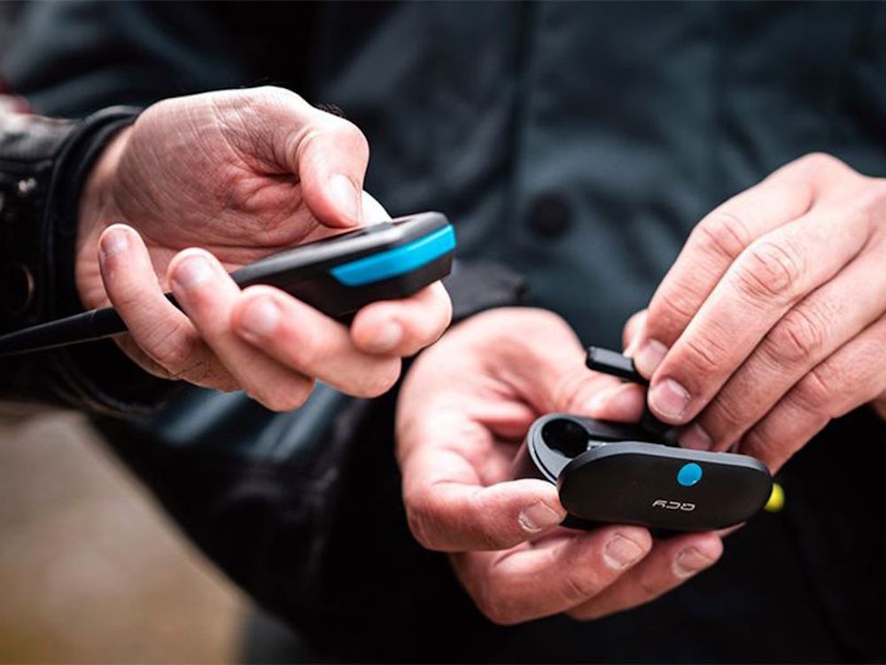 De Sena MeshPort Blue Bluetooth headset naar Mesh Intercom adapter in gebruik met draadloze Bluetooth oordopjes