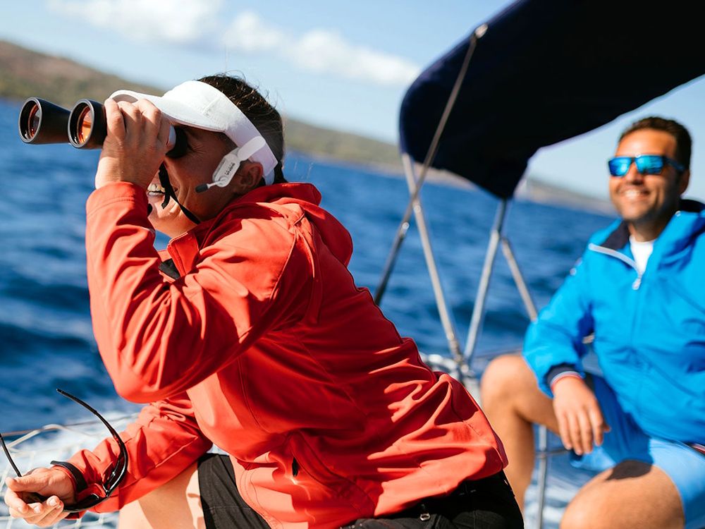 De Sena Nautitalk Crew headset voor communicatie op het water in gebruik op een boot en bevestigd aan een pet
