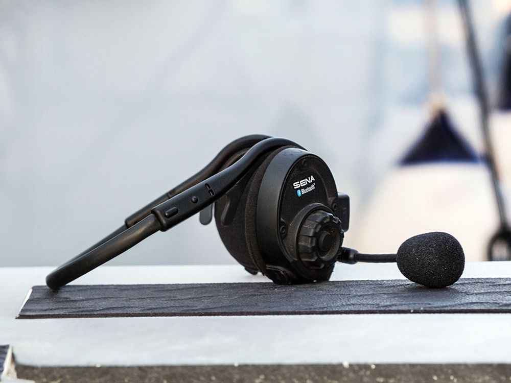 De Sena SPH10 outdoor Bluetooth headset voor Intercom en muziek delen liggend op een bankje in de haven