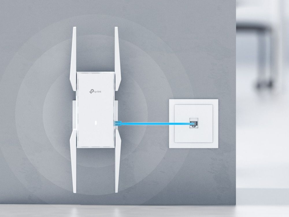 De TP-Link Omada EAP673-Extender wall-plate mesh WiFi 6 versterker met externe antennes in een kantoorruimte gemonteerd aan de muur en aangesloten op een netwerk